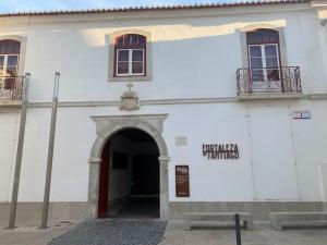 un edificio blanco con una puerta y un arco en Casa da fortaleza en Sesimbra