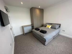 Dormitorio pequeño con cama y TV en Sunny Modern, 1 Bed Flat, 15 Mins Away From Central London, en Hendon