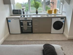 a kitchen with a stove and a sink and a dishwasher at Sunny Modern, 1 Bed Flat, 15 Mins Away From Central London in Hendon