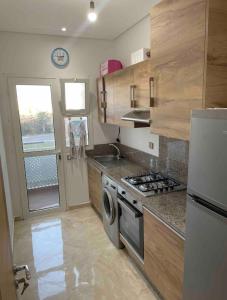 a small kitchen with a stove and a sink at Cosy Apartment with sea view in Sidi Rahal
