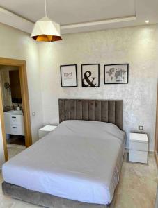 a bedroom with a bed and three pictures on the wall at Cosy Apartment with sea view in Sidi Rahal