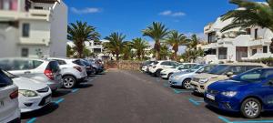 rząd zaparkowanych samochodów na parkingu w obiekcie El Gueco Holiday Apartment w Costa Teguise