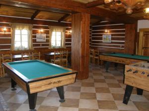 a pool table in a room with tables and chairs at Horsky hotel Stumpovka in Rokytnice nad Jizerou