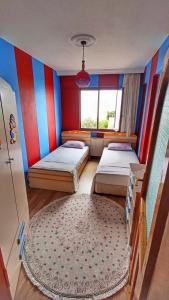 Cette chambre comprend 2 lits et un tapis. dans l'établissement Tepedeki Ev, à Akcaabat