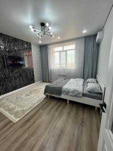 a bedroom with a bed and a fireplace in it at Комфортабельный апартамент: ЖК “Abyroy Residence“ in Atyraū