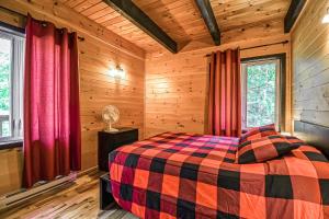 ein Schlafzimmer mit einem Bett in einem Blockhaus in der Unterkunft Brown Bear Lodge in Brownsburg