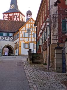 a city street with buildings and a clock tower at Maisonette-Appartment in historischem Ambiente in Iphofen