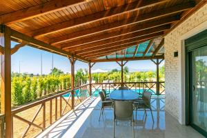 a patio with a table and chairs and a view of a vineyard at Paradise Town Villa Belhamra in Belek