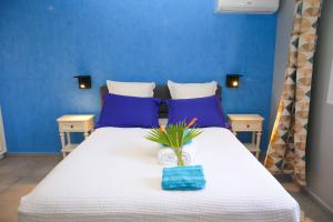 a bedroom with a white bed with blue walls at LES NUITS GALANTES VILLA PETREA PISCINE PRIVÉE in Saint-François +18 photos