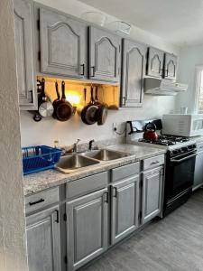 a kitchen with stainless steel cabinets and a sink at Shaligohomes On 16th Ave in Anchorage