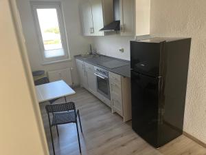 a kitchen with a black refrigerator and a table at Monteur-Pension N2 