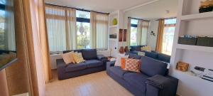 salon z 2 niebieskimi kanapami i oknami w obiekcie El Gueco Holiday Apartment w Costa Teguise