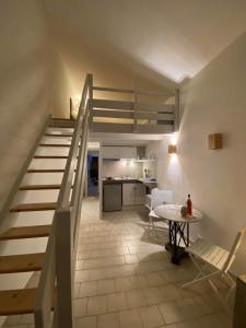 a staircase in a room with a table and a kitchen at Charming house close to the Plage des Huttes in Chaucre