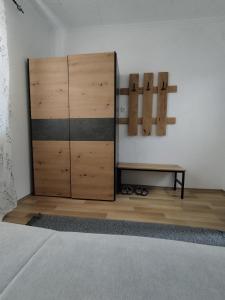 a bedroom with a bed and a wooden cabinet at Jaz Apartman in Bajina Bašta