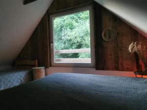 a bedroom with a large window in a attic at Olejarnia Godki in Jonkowo