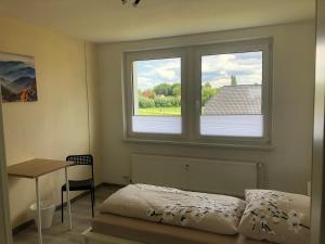 a bedroom with a bed and a window and a table at Monteur-Pension N2 