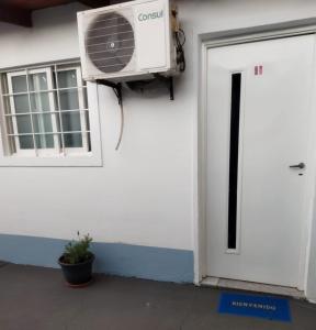 una puerta blanca con ventilador junto a un edificio en Sencillo PH zona céntrica en Posadas