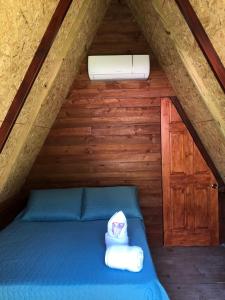 Un dormitorio con una cama azul con toallas. en Casa Santa Teresita - Cabaña tipo glampling en Sanarate
