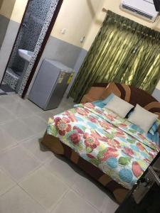 ein Bett mit einer bunten Decke in einem Zimmer in der Unterkunft Comfort Home in Accra