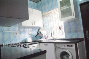 eine Küche mit einer Waschmaschine und einer Waschmaschine in der Unterkunft Comfort Home in Accra
