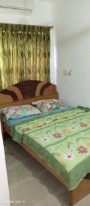 ein Schlafzimmer mit einem Bett mit einer grünen Bettdecke in der Unterkunft Comfort Home in Accra