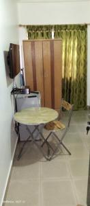 einen Tisch, einen Stuhl und einen TV in einem Zimmer in der Unterkunft Comfort Home in Accra