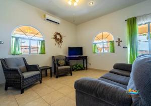 a living room with a couch and chairs and a tv at Mountain side Delight - Palapas house San Felipe Vacation Rental in Playa El Paraíso