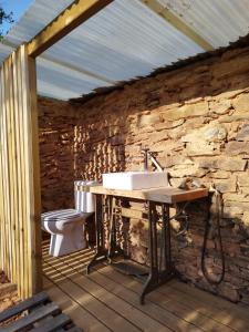 a stone walled bathroom with a sink and a toilet at Herdade da Maceira in São Luis