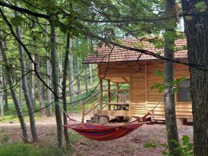 a hammock in front of a cabin in the woods at Cowboy House at Ranch Lambergar 