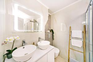 ein weißes Badezimmer mit Waschbecken und Spiegel in der Unterkunft Via Porta Raimonda (Luxury central detached house) in Korfu-Stadt + 19 Fotos