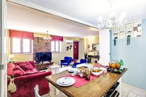 un soggiorno con tavolo e divano rosso di Via Porta Raimonda (Luxury central detached house) a Città di Corfù