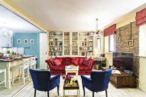 a living room with a red couch and a kitchen at Via Porta Raimonda (Luxury central detached house) in Corfu