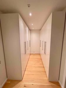 a hallway with white cabinets and a wooden floor at Luxuswohnung 95qm in Waldrandlage zwischen Köln und Düsseldorf-Nähe Messe - Lanxessarena - Bayarena in Leverkusen