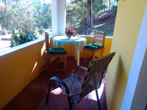 een veranda met een tafel en stoelen en een raam bij Mangaratiba Lazer e paz na Mata Atlântica in Mangaratiba