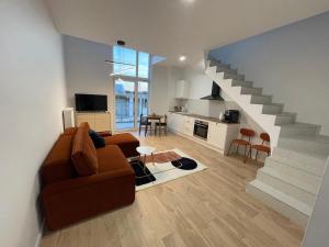 Una sala de estar con un sofá y una escalera. en Porto Mare Apartament Mechelinki, en Mechelinki