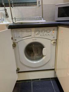 a washing machine in a kitchen with a microwave at The White House! Beautiful 4 Bed 3 Bath Sleeps 11 in St. Albans