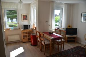 a living room with a dining room table and chairs at Ferienwohnung Sonnenblume in Hohegeiß