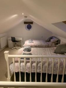 a bedroom with a bed and a crib in a attic at The White House! Beautiful 4 Bed 3 Bath Sleeps 11 in St. Albans