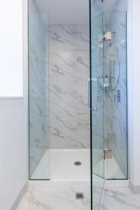 a shower with a glass door in a bathroom at Beautiful Gem by Hagley Park, Central City Chch in Christchurch