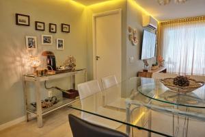 a dining room with a glass table and chairs at TERRAMARIS - APARTAMENTO PÉ NA AREIA in Aquiraz +24 photos