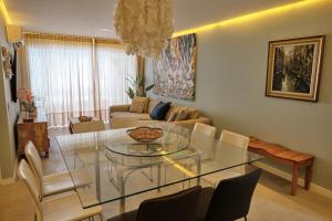 a living room with a glass table and chairs at TERRAMARIS - APARTAMENTO PÉ NA AREIA in Aquiraz