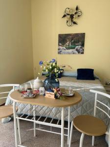 スビアーコにあるGuest House Subiaco LA DOMUSのベッド1台、テーブル(花付)が備わる客室です。