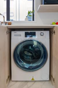 a washing machine with a blue glass door in a kitchen at Beautiful Gem by Hagley Park, Central City Chch in Christchurch