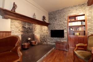 a living room with a stone wall at Casa Passeg dera Libertat 8 in Vielha
