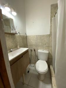 La salle de bains est pourvue de toilettes blanches et d'un lavabo. dans l'établissement Posada El Ceibo, à Puerto Iguazú
