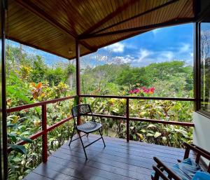 een kamer met een stoel op een houten veranda bij Eden Atenas Costa Rica in Atenas