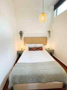 a bedroom with a large bed with two tables at Beautiful Apartment near Carcavelos Beach in Parede