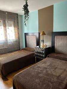 a bedroom with two beds and a lamp on a table at La Casa de Blanca in Candás