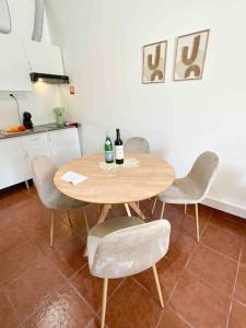a table and chairs in a kitchen with two bottles of wine at Beautiful Apartment near Carcavelos Beach in Parede