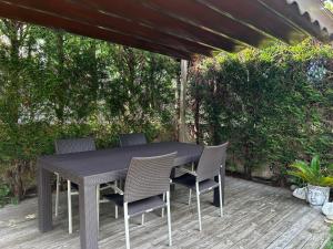 una mesa negra y sillas en una terraza de madera en La Casa de Blanca, en Candás